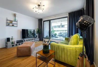 a living room with a yellow couch and a television at Apartment Invalidovna with FREE parking in Prague