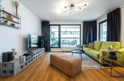 a living room with a couch and a tv at Apartment Invalidovna with FREE parking in Prague