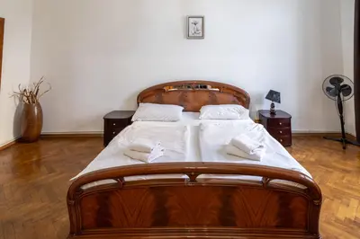 a bedroom with a wooden bed with two towels on it at Downtown Apartments in Prague