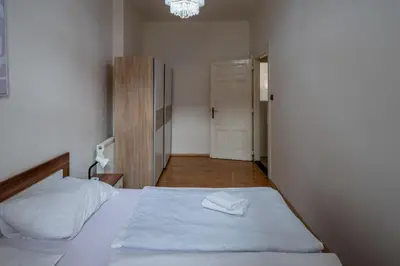 a bedroom with a white bed and a chandelier at Downtown Apartments in Prague