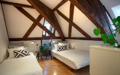 two beds in a attic room with wooden beams at Ericsson Palace in Prague
