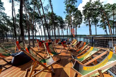a group of chairs sitting on a deck next to the water at Villa Lhota in Lhota