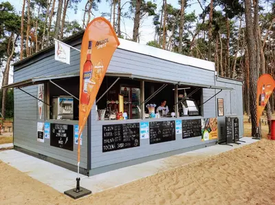 a food stand on the beach with a man ordering at Villa Lhota in Lhota