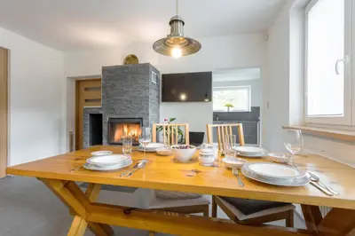 a dining room with a wooden table and a fireplace at Villa Lhota in Lhota