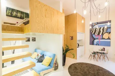 a living room with a blue couch and a table at Ruterra Studio with Private Terrace in Prague