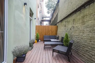 a patio with two chairs and a table on a brick wall at Ruterra Studio with Private Terrace in Prague