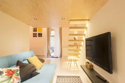 a living room with a blue couch and a flat screen tv at Ruterra Studio with Private Terrace in Prague