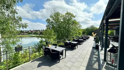 a row of tables and chairs next to a river at Exclusive Pension Vista Mlada Boleslav in Bradlec