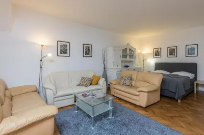 a living room with two couches and a bed at Apartman Carolinum in Prague