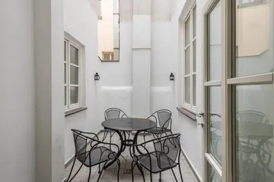 a table and chairs in a room with windows at Apartman Carolinum in Prague