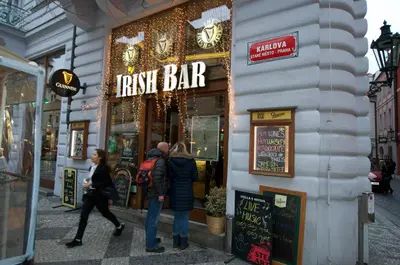 a group of people walking in front of a pizza bar at Apartman Carolinum in Prague