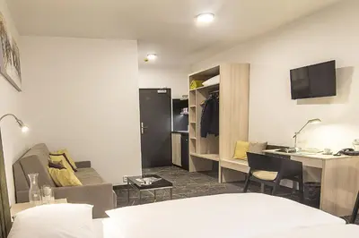 a hotel room with a bed and a desk at Hotel Valcha in Prague