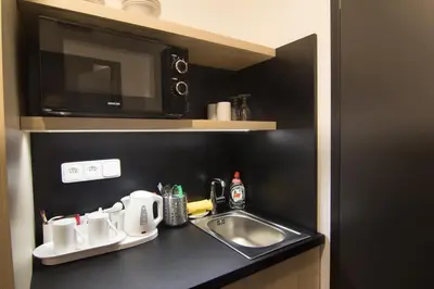 a kitchen counter with a sink and a microwave at Hotel Valcha in Prague