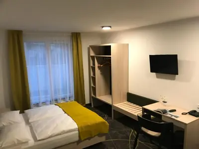 a living room with a couch and a bed at Hotel Valcha in Prague