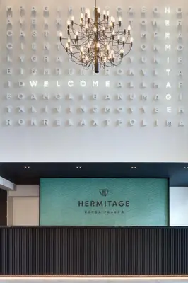 a chandelier hangs above a sign in a store at Hermitage Hotel Prague in Prague