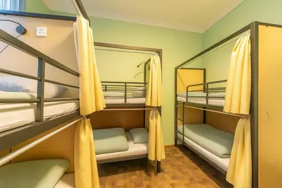 a small room with bunk beds with yellow curtains at Best Spot Hostel in Prague