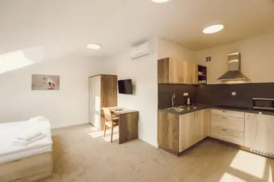 a kitchen with wooden cabinets and a table in a room at Kings Residence in Prague