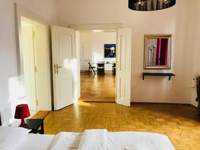 a bedroom with a bed and a hallway with a desk at Royal Road Residence II in Prague