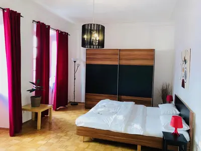 a bedroom with a bed and red drapes at Royal Road Residence II in Prague