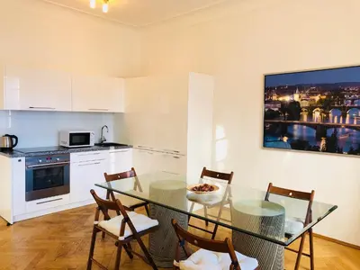 a kitchen with a glass table and some chairs at Royal Road Residence II in Prague