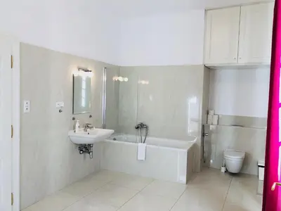 a bathroom with a sink and a tub and a toilet at Royal Road Residence II in Prague