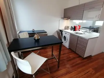 a kitchen with a table and a sink and a washing machine at Golden Family Apartments in Prague