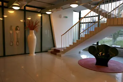 a lobby with a staircase and a vase with a sculpture at Golden Family Apartments in Prague