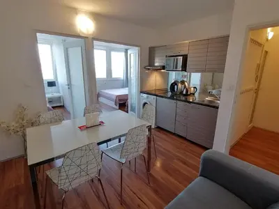 a kitchen and living room with a table and chairs at Golden Family Apartments in Prague