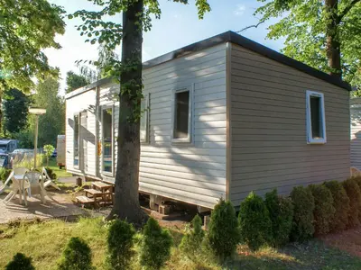 a tiny house sitting in a yard next to a tree at Holiday Home Hawaii Style by Interhome in Prague