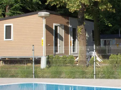 a house with a fence in front of a tree at Holiday Home Hawaii Style by Interhome in Prague