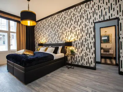 a bedroom with a bed and a large mirror at Golden Prague Rooms in Prague