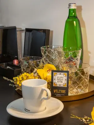 a cup of coffee on a table with a bottle of wine at Golden Prague Rooms in Prague