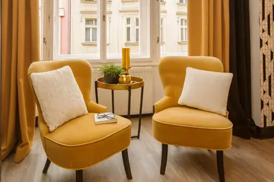 two yellow chairs sitting next to a window at Golden Prague Rooms in Prague