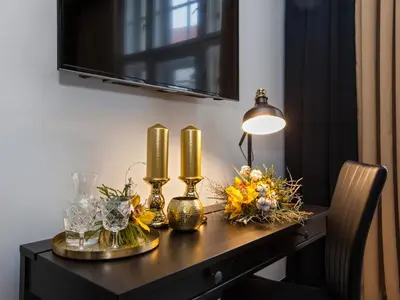 a table with two candles and flowers on it at Golden Prague Rooms in Prague