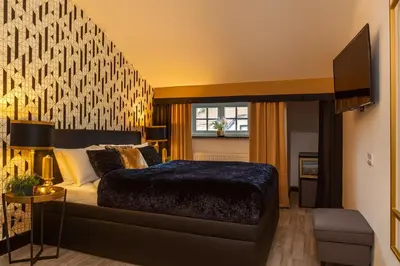a bedroom with a large bed with a large wall at Golden Prague Rooms in Prague