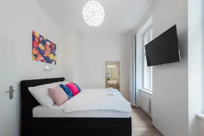 a bedroom with a bed with a tv on the wall at Residence Tesnov Apartment in Prague