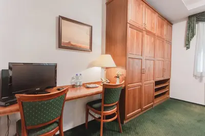 a room with a desk with a computer and chairs at Hotel Peko in Prague