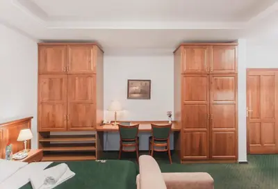 a bedroom with wooden cabinets and a table and chairs at Hotel Peko in Prague