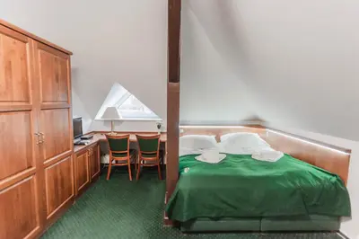 a bedroom with a bed and a desk with chairs at Hotel Peko in Prague