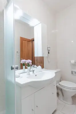 a white bathroom with a sink and a toilet at Hotel Peko in Prague