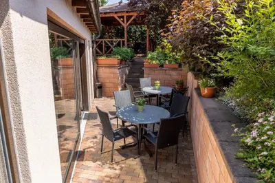 a patio with a table and chairs and plants at Hotel Kanarek in Prague