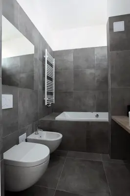 a bathroom with a tub and a toilet and a sink at The Apartment House - Mezibranska in Prague
