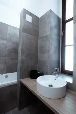 a bathroom with a white sink and a bath tub at The Apartment House - Mezibranska in Prague