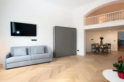 a living room with a couch and a flat screen tv at The Apartment House - Mezibranska in Prague