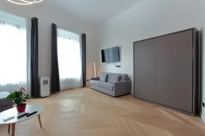 a living room with a tv and a couch and a table at The Apartment House - Mezibranska in Prague