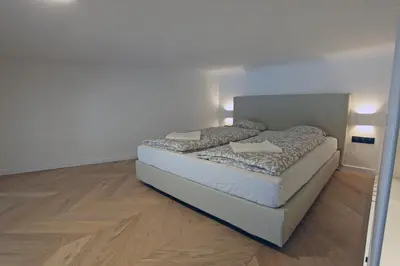 a bed in a room with a mirror at The Apartment House - Mezibranska in Prague
