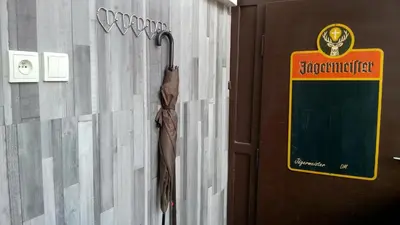 an umbrella is hanging on a wall next to a door at Studio Husitská 114/74 in Prague