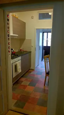 a kitchen with a checkered floor and a table and a chair at Studio Husitská 114/74 in Prague