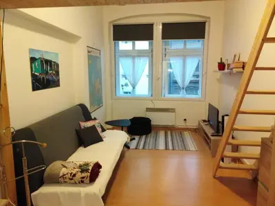 a living room with a couch and a large window at Studio Husitská 114/74 in Prague