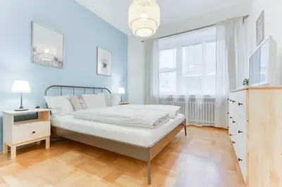 a blue bedroom with a bed and a window at Apartment Alex in Prague